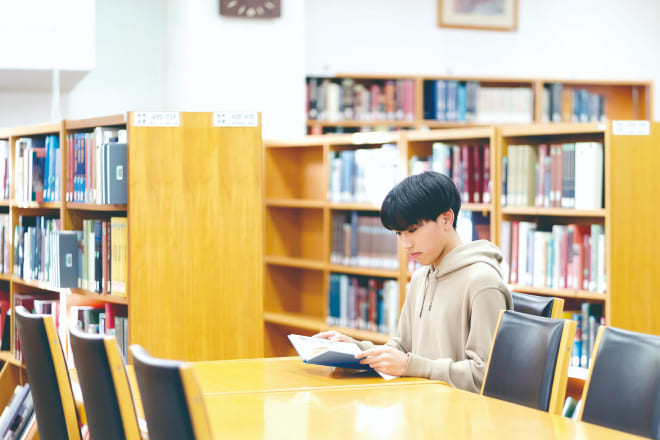 図書館で本を読む大学生